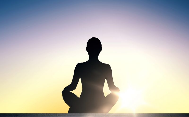 woman meditating at sunrise