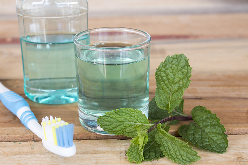 mouthwash, toothbrush & fresh mint leaves