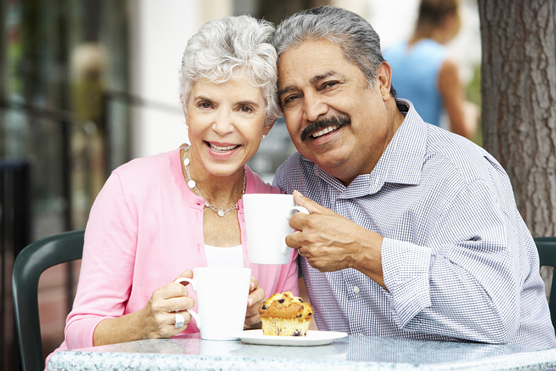 senior couple enjoying beverages and pastries