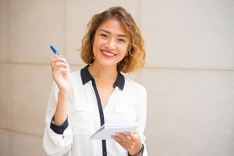 smiling woman taking notes